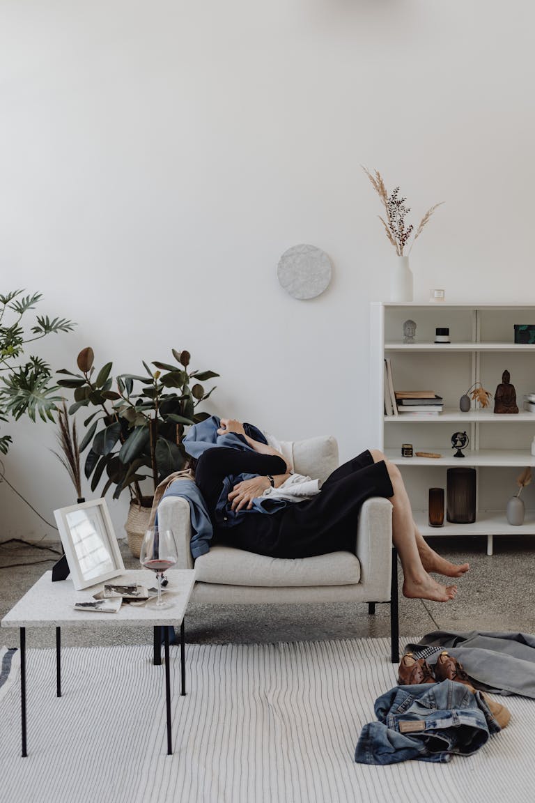 Woman lounging on couch in stylish living room with decor and plants.